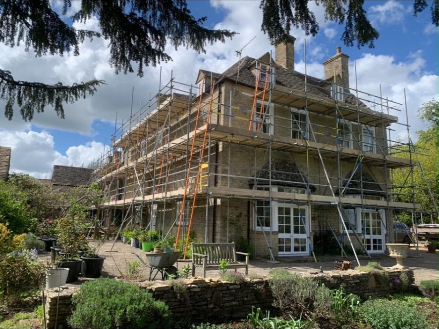 Scaffold with boarded lifts erected around a large stone country house