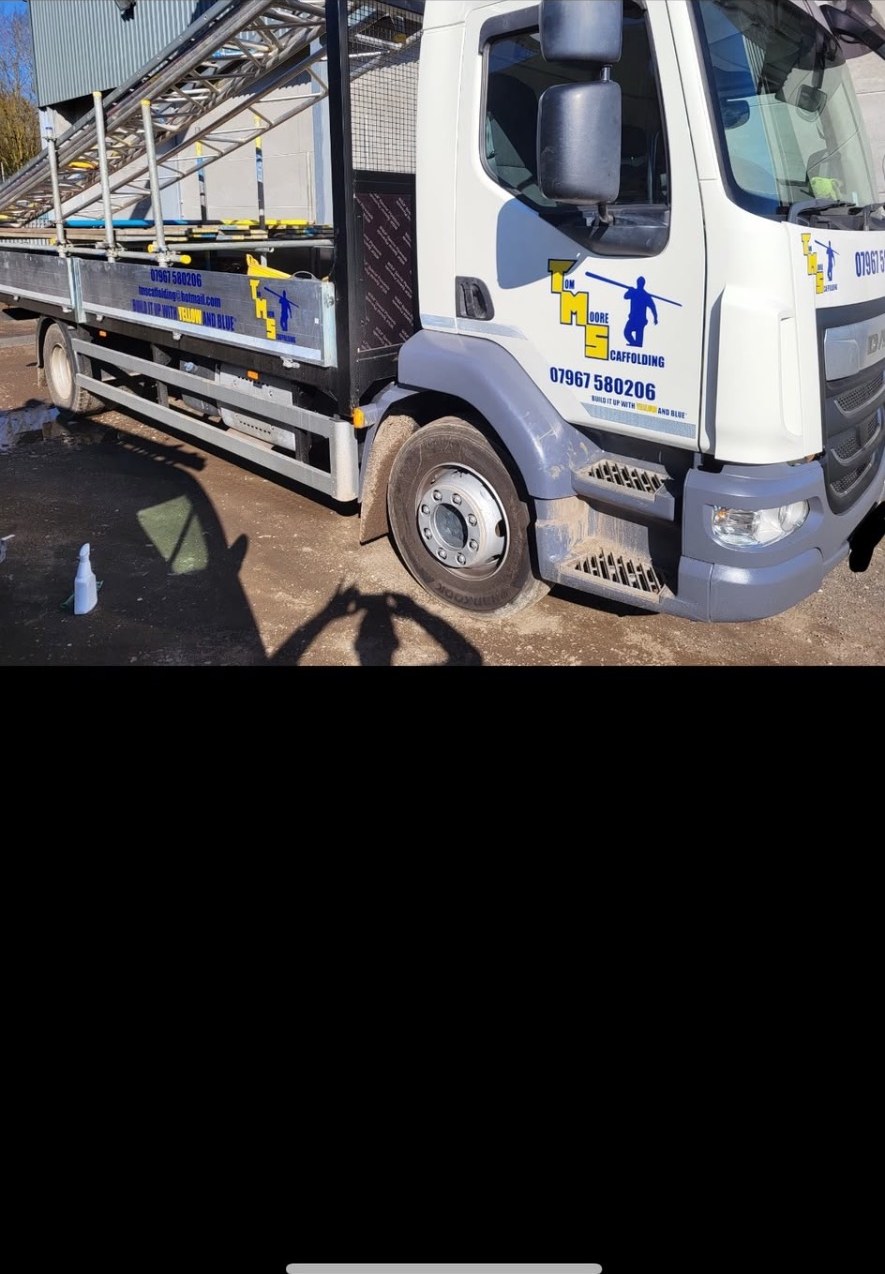 White Tom Moore Scaffolding truck loaded with scaffold tube and boards at the yard